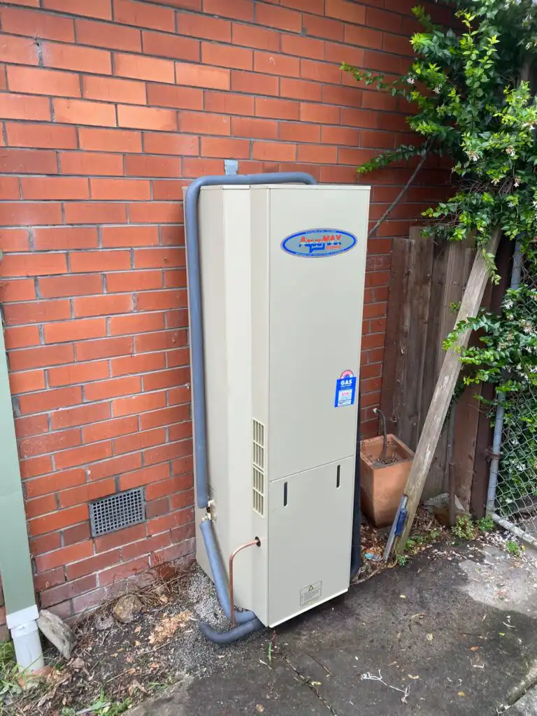 Gas hot water system installation on exterior brick wall
